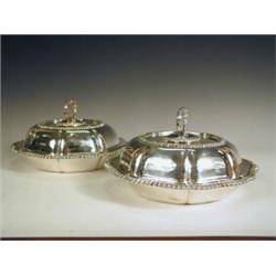 A pair of Edwardian silver entree dishes and covers, of shaped form with gadrooned borders, and s...