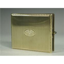 A 14ct gold cigarette case with scroll decorated borders framing vertical bands, the oval cartouc...