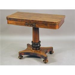A Victorian rosewood fold over card table with a tapering column on a quadripartite base with tur...