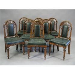 A set of eight Victorian oak single dining chairs with carved arched backs, leather overstuffed s...