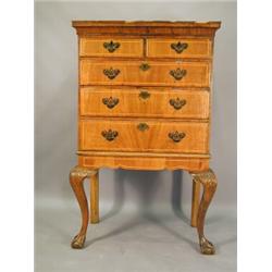 A strung walnut chest of two short and three long drawers, 18th century and later on an associate...
