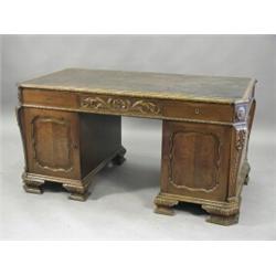 A Chippendale style mahogany twin pedestal desk having a leather writing surface over three friez...