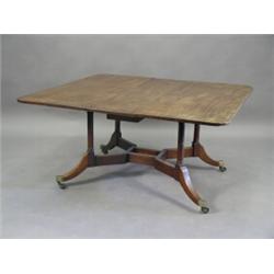 A George III mahogany Cumberland table with drop leaves on turned supports and brass castors, 131...