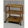 Image 1 : A 1950's walnut and plywood trolley of tapering form, the three graduated trays joined by chamfer...