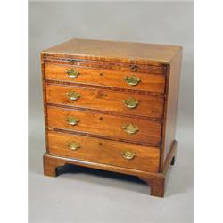 A George III mahogany chest of four long graduating drawers, beneath a brushing slide, raised on...