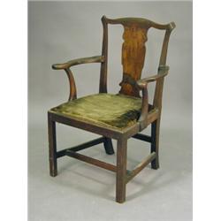 An 18th century mahogany elbow chair with a serpentine top rail over a solid shaped splat and a d...