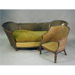 A late 19th century carved mahogany framed bergere salon armchair together with a bergere settee,...