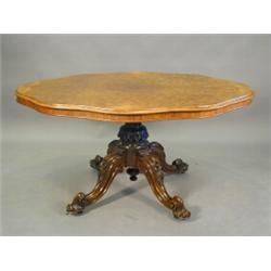 A Victorian burr walnut veneered loo table with a quarter veneered top on four scrolling legs wit...