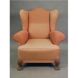 A wing armchair with pink covers and carved paw feet, 20th century Est. 200/300...
