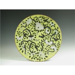 A large yellow ground Chinese dish, with black chi lung wreathing amongst white enamel peony a...