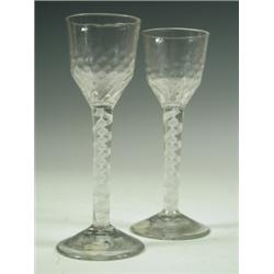 Two 18th Century cordial glasses with panelled bowls on opaque twist stems, the feet probably...