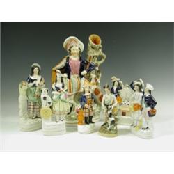 A collection of seven Victorian Staffordshire figures, comprising: A large figure of a huntsma...