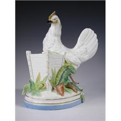 A 19th Century porcelain model of a chicken beside a spill holder with foliage, upon an oval b...