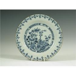 A mid 18th Century delft plate, decorated with a vase and flowers, possibly Lambeth, 23cm diam...