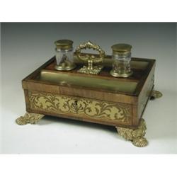 A Regency rosewood and brass inlaid inkstand with a central leaf cast handle flanked by glass...