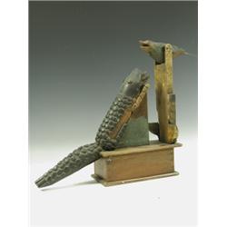 A late 19th Century American 'Folk Art' wooden money box, formed as a tilting bird feeding a c...