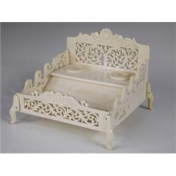 An Indian carved ivory desk stand, with removable inkwells, and fretwork decoration, 17cm wide...