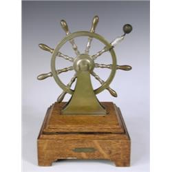 A Victorian country house bell in the form of a brass ship's wheel upon an oak base, struck 'B...