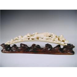 A late l9th Century Japanese carved ivory tusk on a carved wood base, length of tusk 31.5cm<br...