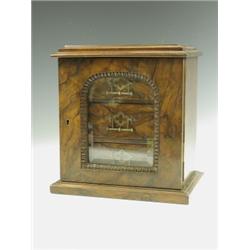 A Victorian walnut table top cabinet, with an arched and glazed door, opening to reveal three...