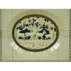 A late 19th Century/early 20th Century carved ivory oval of three deer and a stag in woodland...