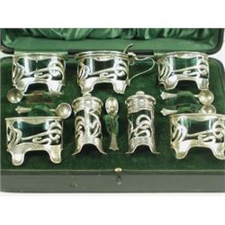 A seven piece Art Nouveau silver condiment set with matching spoons, in a presentation case, B...