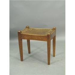 An Arts & Crafts oak stool with a gently shaped plank seat on square tapering legs Est. 100...