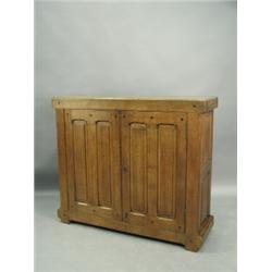 An Arts & Crafts oak two door cupboard with visible ebonised tenons, having two double panelle...