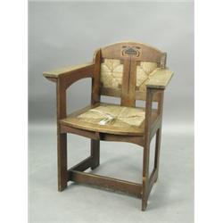 An Arts & Crafts oak arm chair attributed to E G Punnet and manufactured by William Birch c.19...