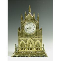 A late Victorian brass cathedral clock, the turreted case with a porcelain dial and a cut plat...