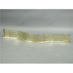 A 19th Century pierced brass fender, each panel decorated with winged beasts holding a crown,...