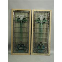 A pair of Art Nouveau leaded glass window panels, each with stylised decoration, 130cm x 54cm<...