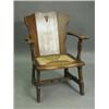An oak Arts & Crafts style armchair having a three piece plank back with a pierced arrowhead m...