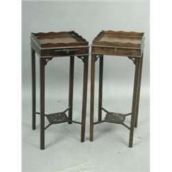 A pair of early 20th Century mahogany tray top nightstands, with candle slides and lower shape...