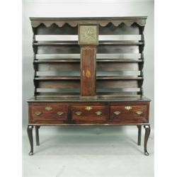 An 18th Century oak dresser base, with a late 19th Century rack, including a clock, the 10 inc...