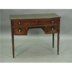 An early 19th Century mahogany bow fronted dressing table with an ebony strung top and cock be...