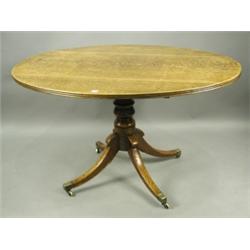 A Regency oak oval top loo table, with reeded edge, turned column stem, raised on swept quadri...