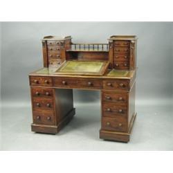 A Victorian mahogany 'Dickens' desk, the top with two columns of drawers, a gallery and a rais...