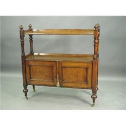 A Victorian oak buffet with two tiers surmounted with gadrooned finials, over two cupboard doo...