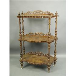 A Victorian walnut whatnot, with three shaped tiers, each backed with a pierced gallery, on tu...