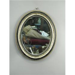 A 19th Century Irish oval mirror with an ebonised and silvered frame, 58cm high Est. 100/150...