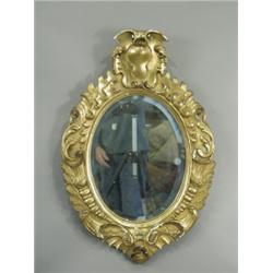 A 19th Century Italian oval wall mirror in a carved and gilt frame, now painted gold, 72cm hig...