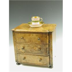 A miniature walnut chest of three drawers with knob handles and bun feet, 31cm wide x 29cm hig...