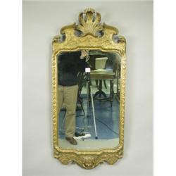 A George II style wall mirror, the carved, tooled and gilt frame with a broken scrolled pedime...