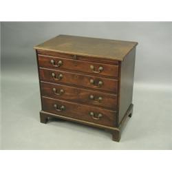 A George III mahogany chest, of small proportions, the well figured top above a slide and four...