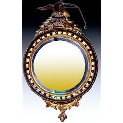 An early 19th Century giltwood convex mirror, with gilt eagle finial on rocky outcrop and dished...