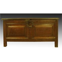 An early 18th Century oak blanket chest, the twin fielded hinged top above a panelled front, on s...