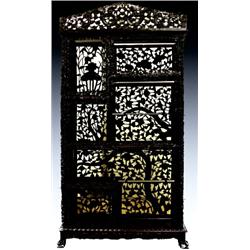 A Japanese pierced hardwood and ebonised display stand, with crested scrolling dragon pediment an...