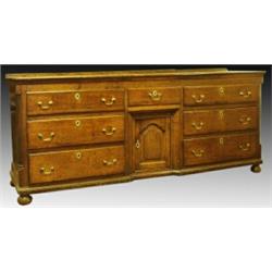 A George III oak dresser, circa 1780, the planked rectangular top above a short central drawer an...