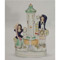 Hand painted Victorian Staffordshire figure group, depicting a Scotsman and seated woman beside a…